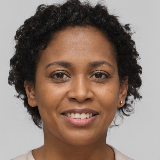 Joyful black adult female with short  brown hair and brown eyes