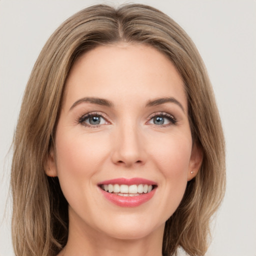 Joyful white young-adult female with long  brown hair and green eyes