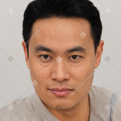 Joyful asian young-adult male with short  black hair and brown eyes