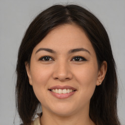 Joyful latino young-adult female with long  brown hair and brown eyes