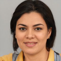 Joyful latino young-adult female with medium  brown hair and brown eyes