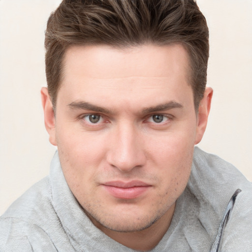 Joyful white young-adult male with short  brown hair and grey eyes