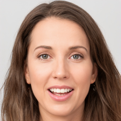 Joyful white young-adult female with long  brown hair and green eyes