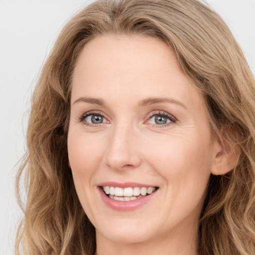 Joyful white young-adult female with long  brown hair and blue eyes