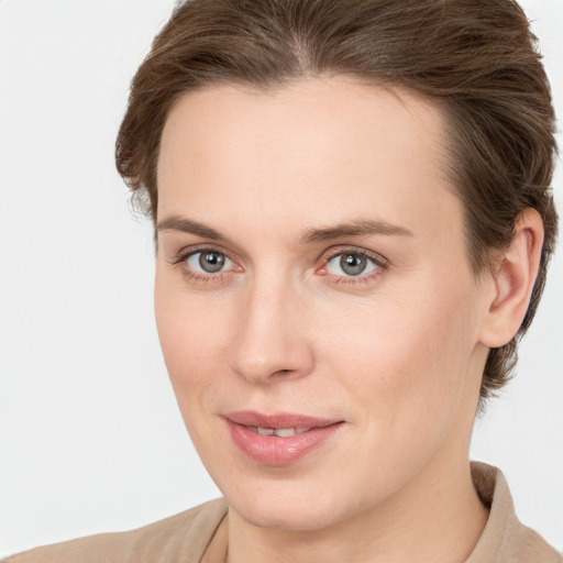 Joyful white young-adult female with medium  brown hair and grey eyes