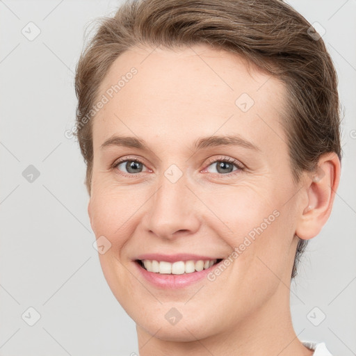 Joyful white young-adult female with short  brown hair and grey eyes