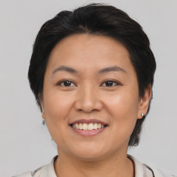 Joyful asian young-adult female with short  brown hair and brown eyes