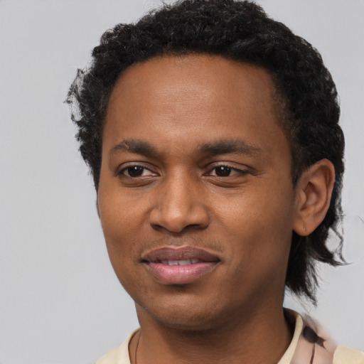 Joyful black young-adult male with short  black hair and brown eyes