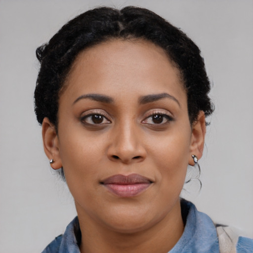 Joyful black young-adult female with short  black hair and brown eyes