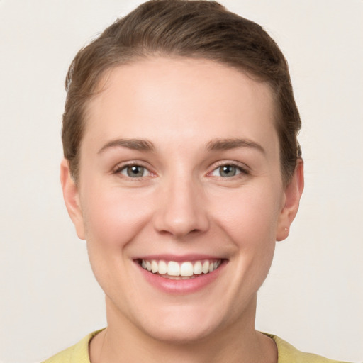 Joyful white young-adult female with short  brown hair and grey eyes