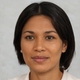 Joyful latino adult female with medium  brown hair and brown eyes