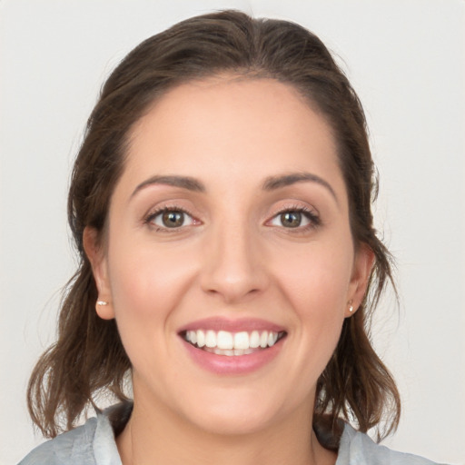 Joyful white young-adult female with medium  brown hair and blue eyes