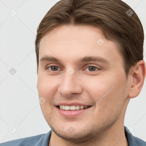 Joyful white young-adult male with short  brown hair and grey eyes