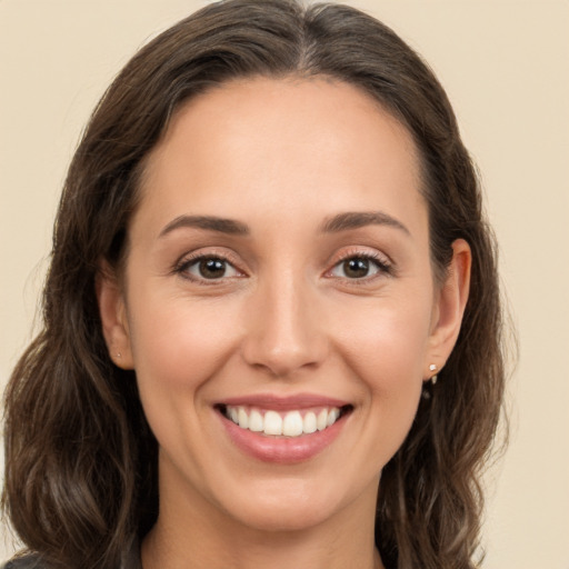 Joyful white young-adult female with long  brown hair and brown eyes