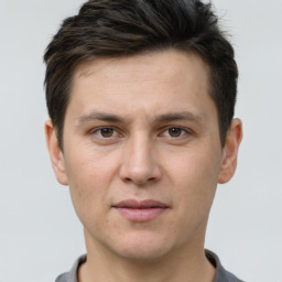 Joyful white young-adult male with short  brown hair and grey eyes