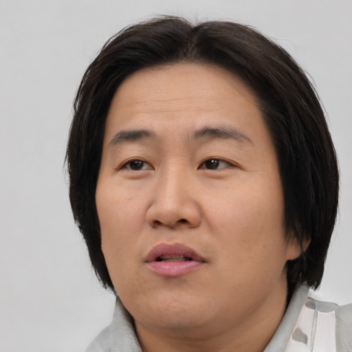 Joyful asian adult female with medium  brown hair and brown eyes