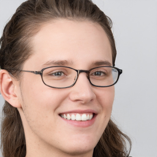 Joyful white adult female with long  brown hair and blue eyes