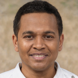 Joyful black adult male with short  brown hair and brown eyes