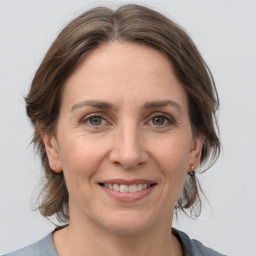 Joyful white adult female with medium  brown hair and grey eyes