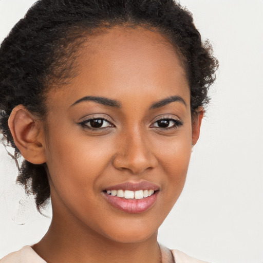 Joyful black young-adult female with long  brown hair and brown eyes