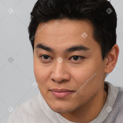 Joyful asian young-adult male with short  brown hair and brown eyes