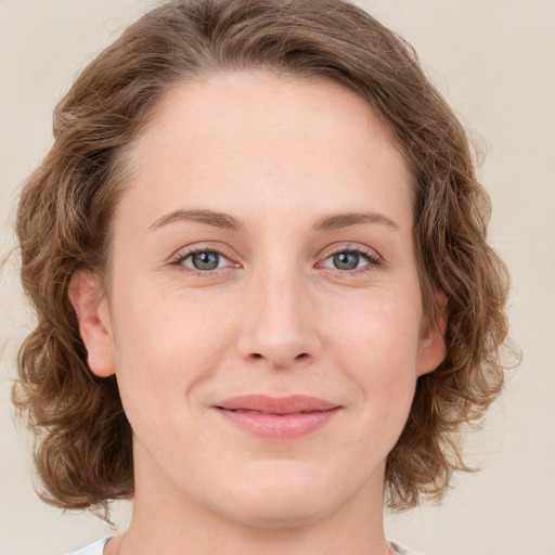 Joyful white young-adult female with medium  brown hair and green eyes