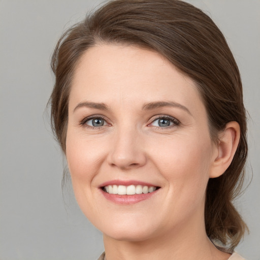 Joyful white young-adult female with medium  brown hair and grey eyes