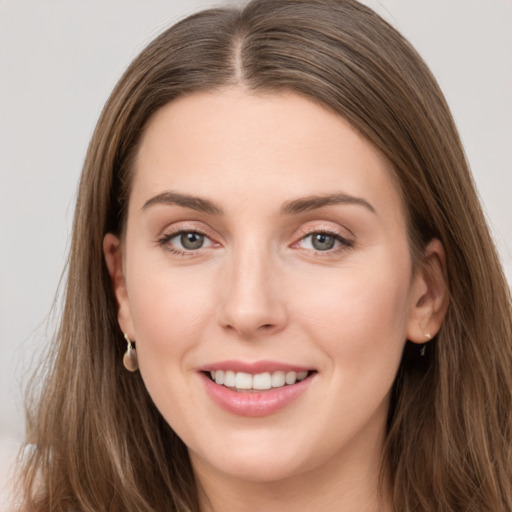 Joyful white young-adult female with long  brown hair and grey eyes