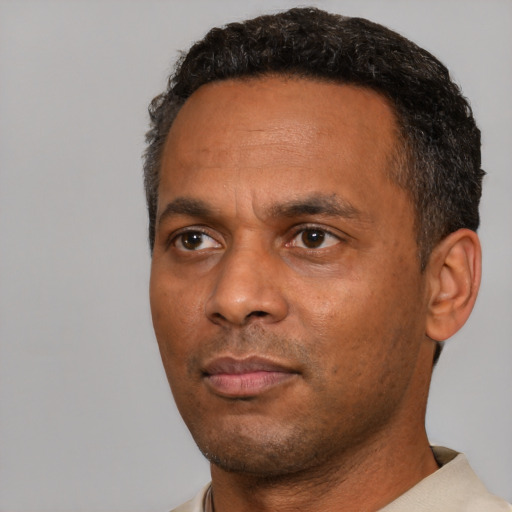 Neutral black adult male with short  black hair and brown eyes