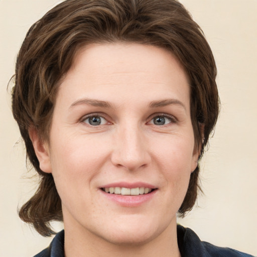 Joyful white young-adult female with medium  brown hair and grey eyes