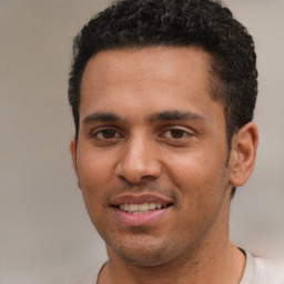 Joyful black young-adult male with short  brown hair and brown eyes