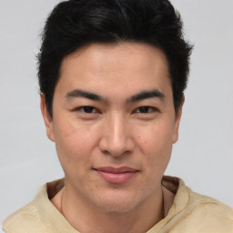 Joyful latino young-adult male with short  brown hair and brown eyes