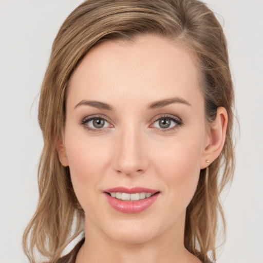 Joyful white young-adult female with long  brown hair and grey eyes