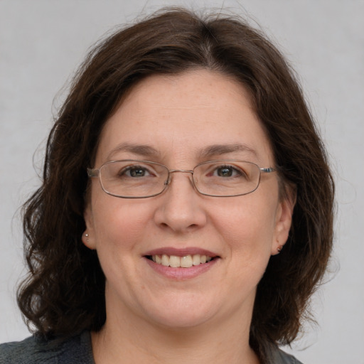 Joyful white adult female with medium  brown hair and green eyes