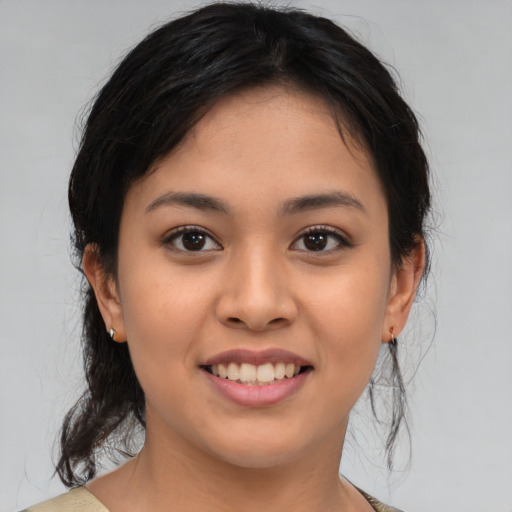 Joyful latino young-adult female with medium  brown hair and brown eyes