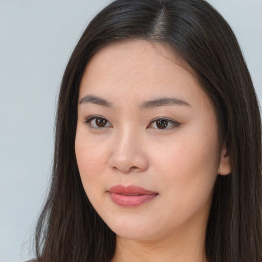 Joyful asian young-adult female with long  brown hair and brown eyes