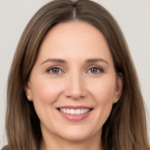 Joyful white young-adult female with long  brown hair and grey eyes