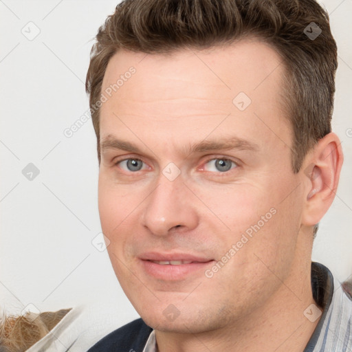 Joyful white adult male with short  brown hair and grey eyes