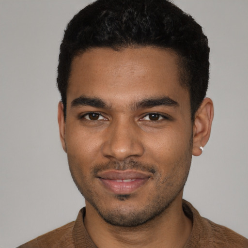 Joyful black young-adult male with short  brown hair and brown eyes