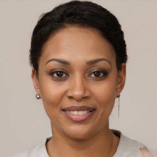 Joyful black young-adult female with short  black hair and brown eyes