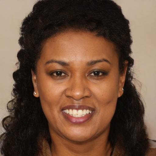Joyful black young-adult female with long  brown hair and brown eyes
