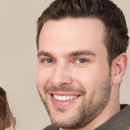 Joyful white young-adult male with short  brown hair and brown eyes