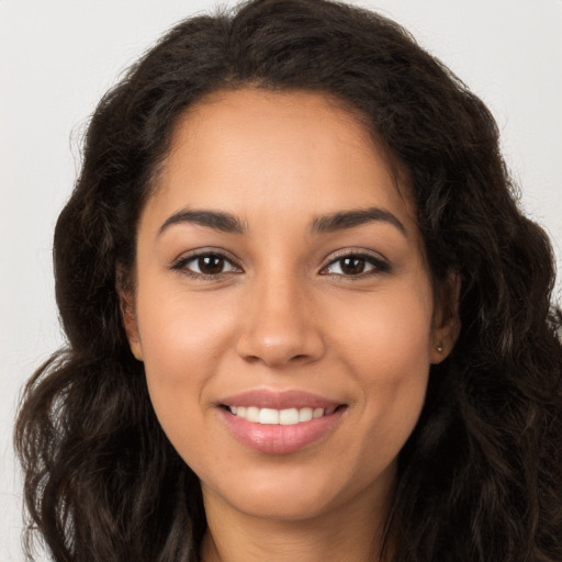 Joyful latino young-adult female with long  brown hair and brown eyes