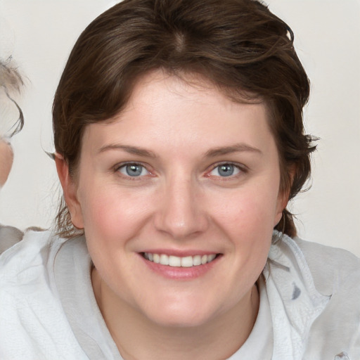 Joyful white young-adult female with medium  brown hair and blue eyes