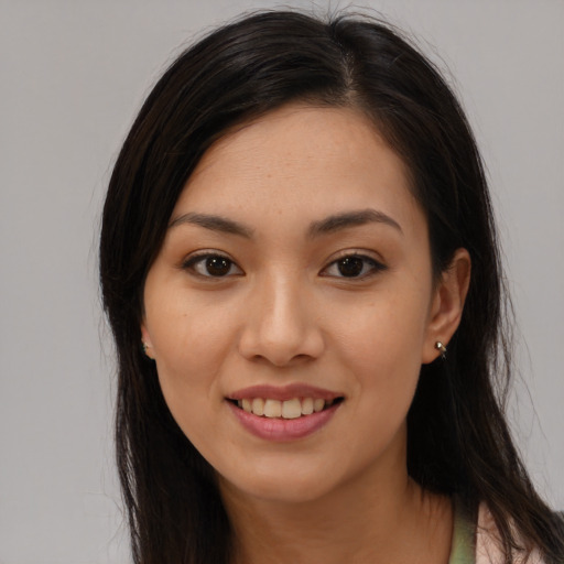 Joyful latino young-adult female with long  brown hair and brown eyes