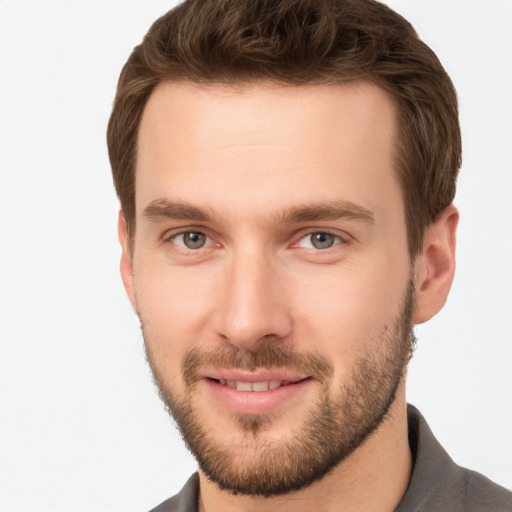 Joyful white young-adult male with short  brown hair and grey eyes