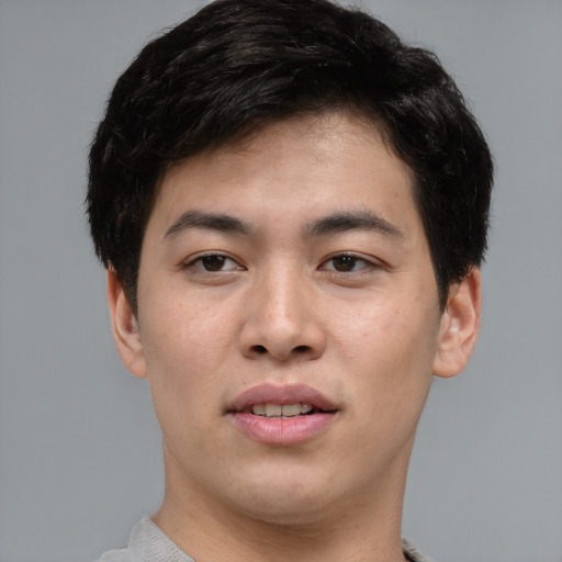 Joyful asian young-adult male with short  brown hair and brown eyes