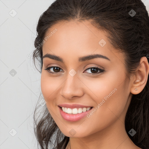 Joyful latino young-adult female with long  brown hair and brown eyes