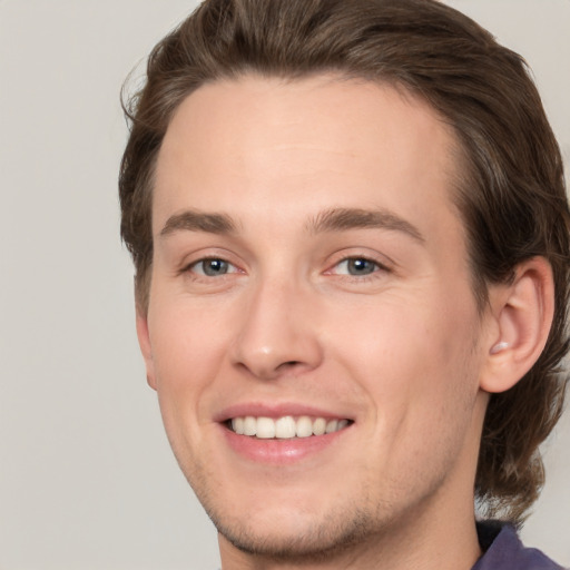 Joyful white young-adult male with medium  brown hair and brown eyes