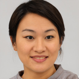 Joyful asian young-adult female with short  brown hair and brown eyes